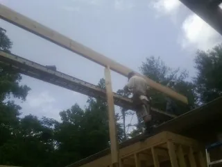 Carpenter setting a ridge beam over a new addition frame — Ice Dam Removal by Roofing Brothers in South Dennis