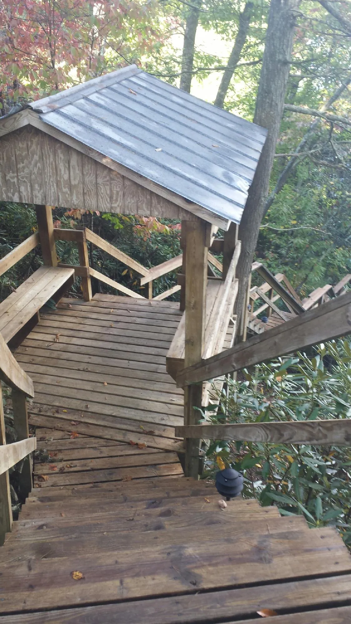Metal roofed shelter over wooden steps on a wooded walkway — Skylight Repair & Installation work by our crew in South Dennis